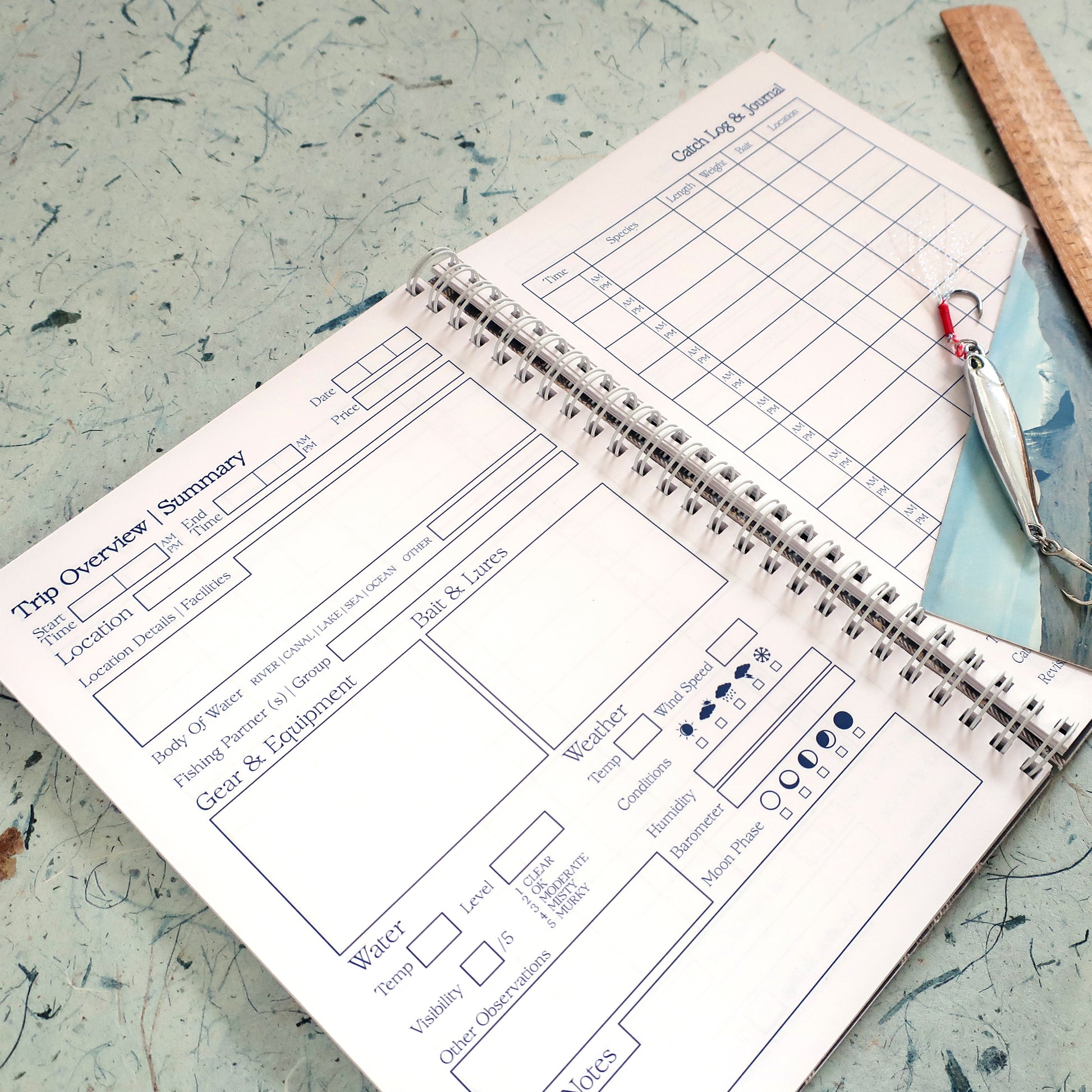 Open fishing log book with catch log and trip overview layout on a textured surface