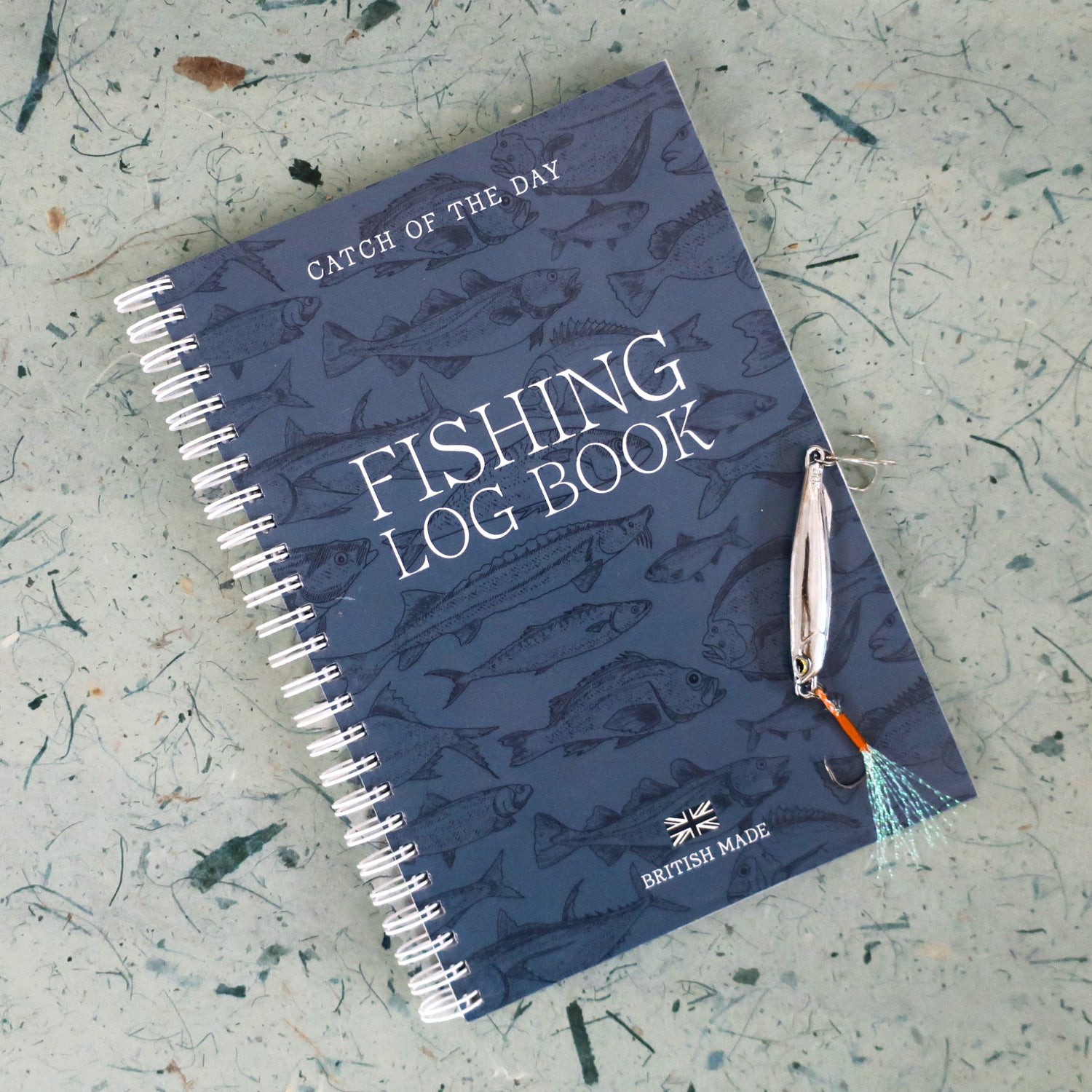 Fishing log book with fishing lure on a textured surface