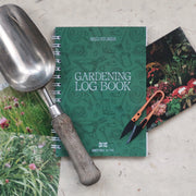 Gardening log book with gardening tools, with vintage garden plants photographs on a textured surface