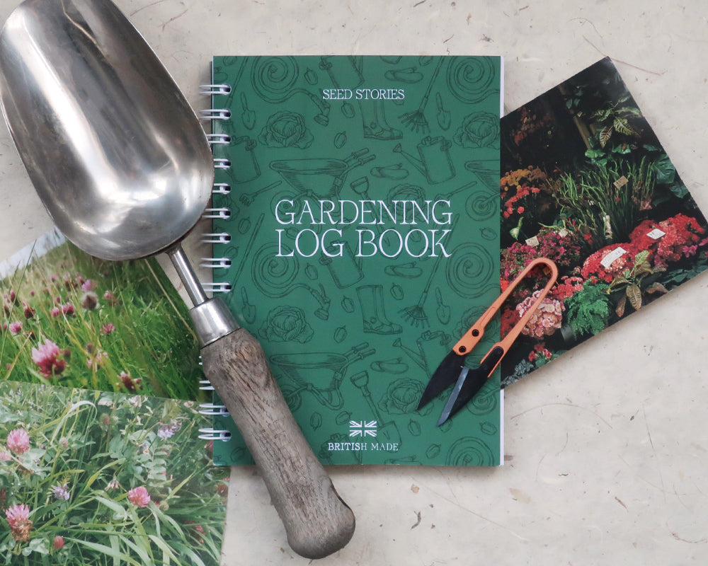 Gardening log book with a trowel and gardening-themed images on a light surface