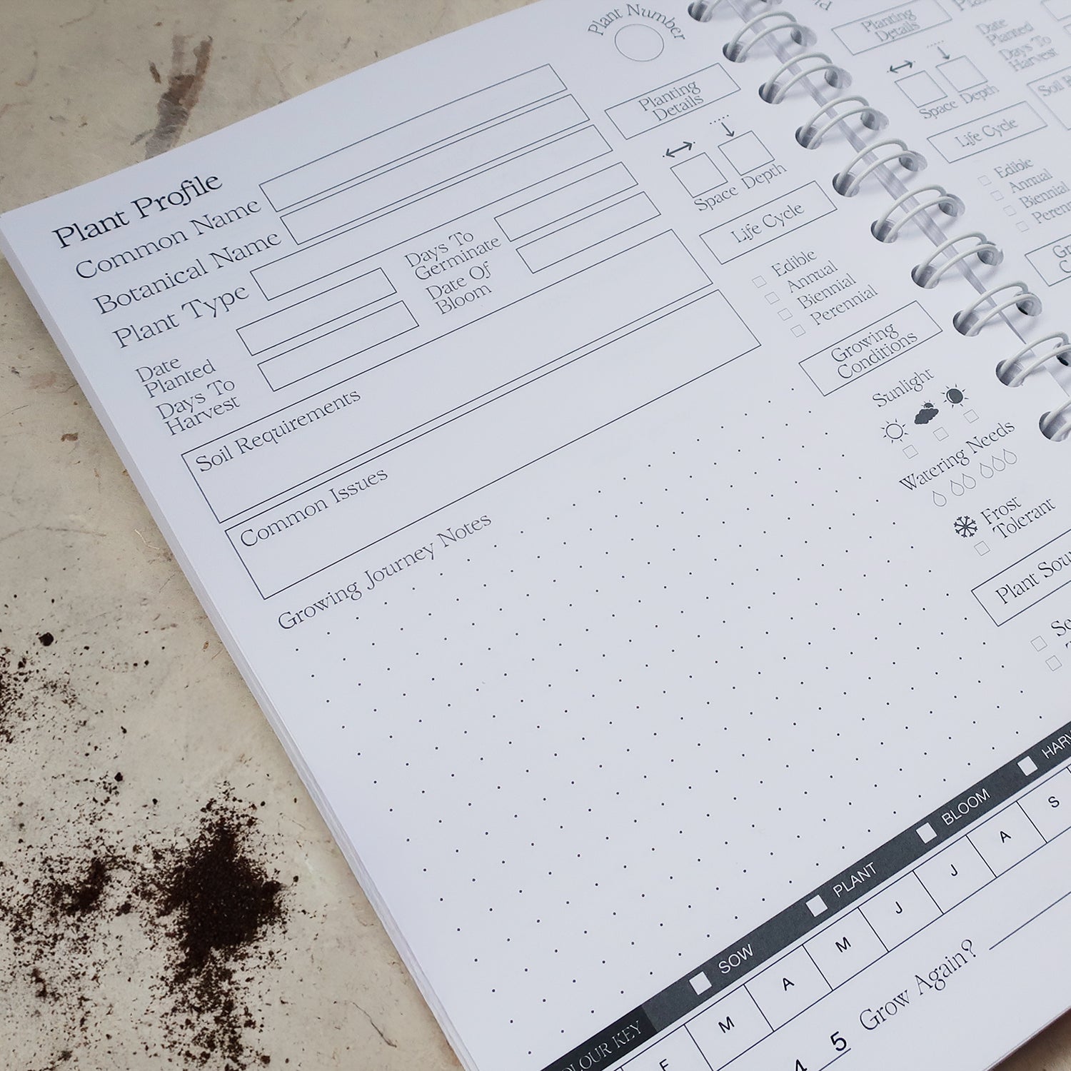 Gardening Log Book open on the Plant Profile page on a soil covered background. 
