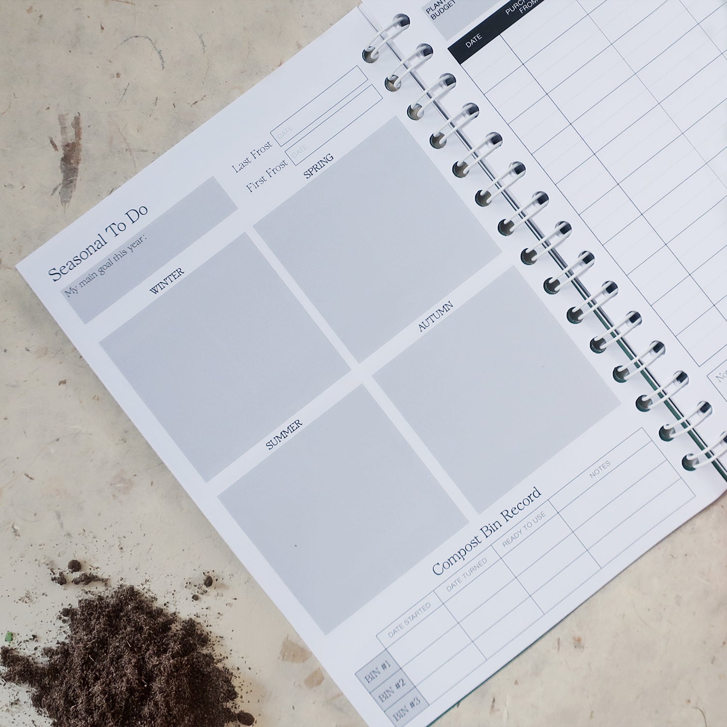 Gardening Log Book open on the Seasonal To Do page, with space to note the main tasks for each season. The ring bound book is laid on a textured surface with a mound of soil.