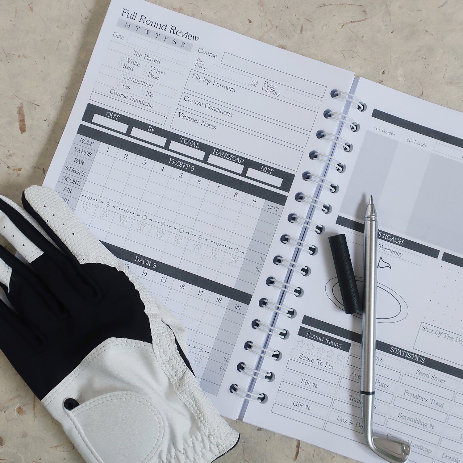 Golf Log Book Open On Full Round Review Double Spread Page, With A Golf Glove & Golf Pen Laid Across Pages