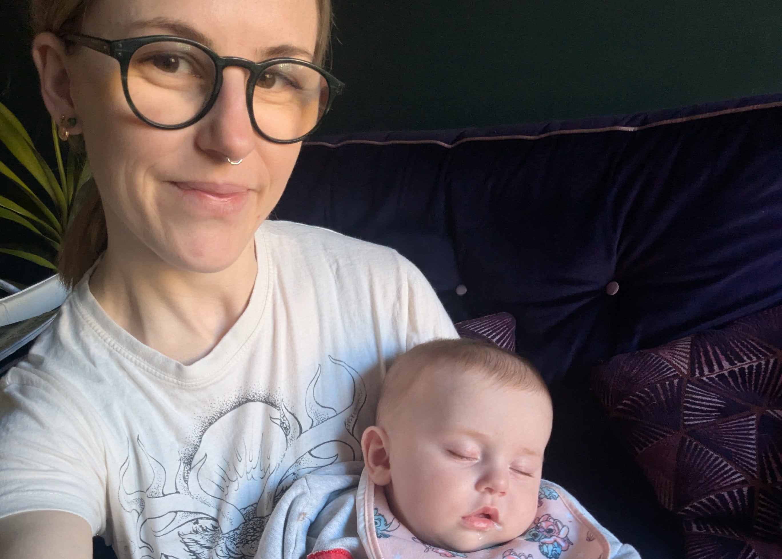 Woman holding a baby in her arms on a couch