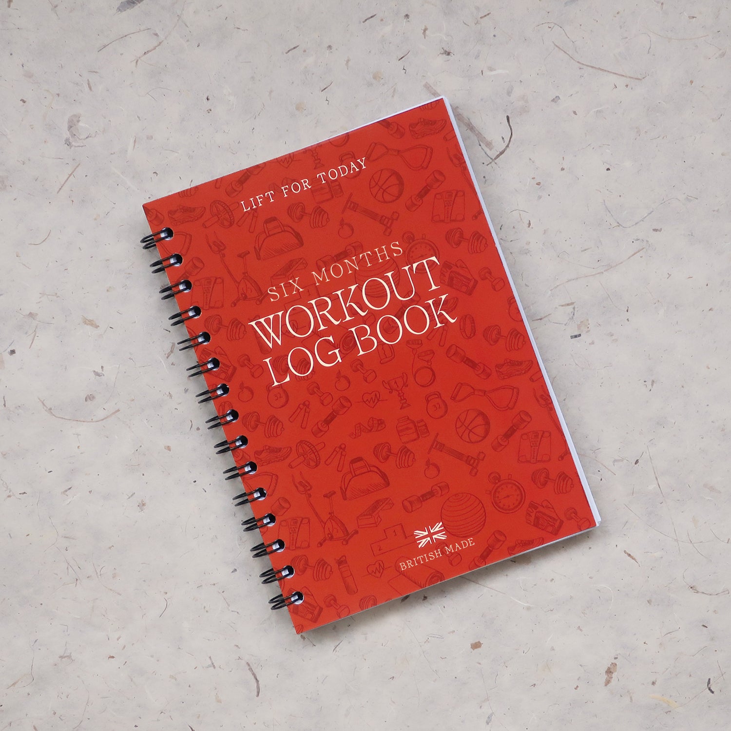 Orange workout log book on light grey texture background