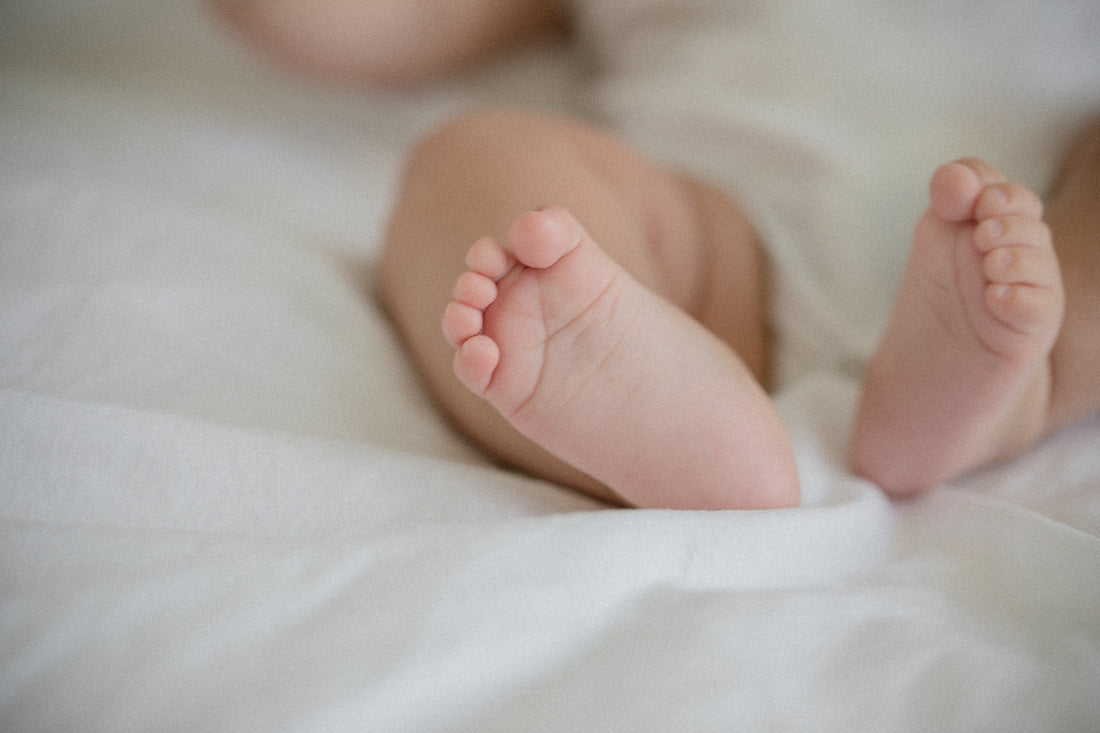 Caucasian Baby Feet On A White Sheet 