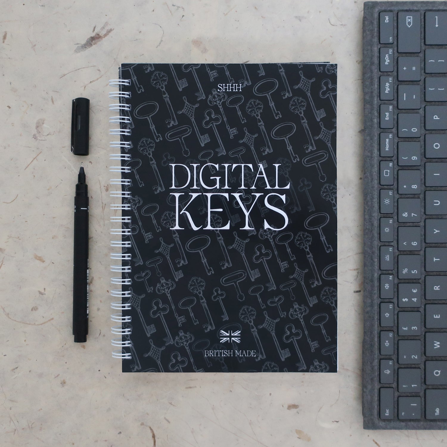 Address & password log book titled 'Digital Keys' with a pen and keyboard on a textured surface