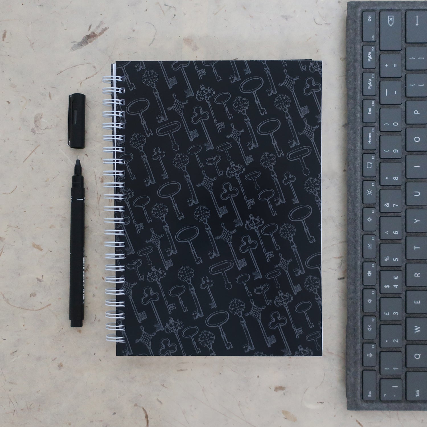 Address & password log book with a pen and keyboard on a textured surface