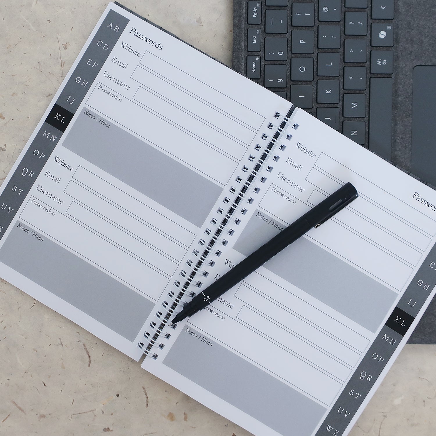 Password manager notebook with a pen on a desk next to a keyboard